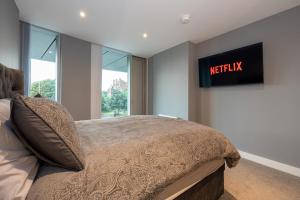 a bedroom with a bed with a night sign on the wall at City Centre Luxury Apartment In Deansgate in Manchester +42 photos