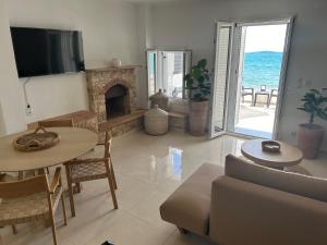 a living room with a couch and a fireplace at Seaside Luxury Komi Beach Villa in Kómi