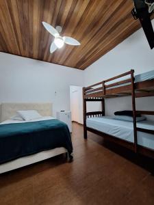 a bedroom with two bunk beds and a ceiling fan at Suítes Pitangueiras - POUSADA FRENTE MAR in Guarujá