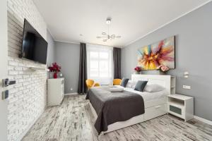 a white bedroom with a bed and a tv at Mikołajska 5 Apartments in Kraków