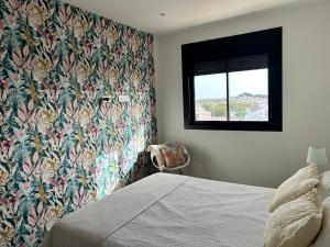 a bedroom with a floral wallpaper and a bed with a window at Appartement VillaCosta in Orihuela +22 photos