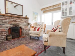a living room with two chairs and a fireplace at Quarry Cottage in Bangor