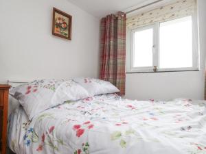 a bedroom with a bed and a window at Quarry Cottage in Bangor