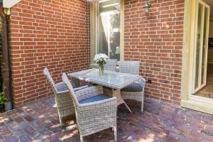 a table and chairs sitting on a brick patio at Up Besöök - Wildrose mit Sauna in Krummhörn +22 photos