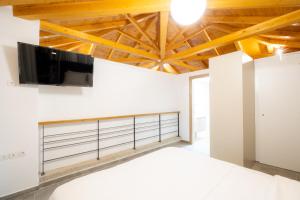 a bedroom with a bed and a tv on a wall at EPOS hotel in Tsagarada