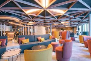 a lobby with a couch and tables and chairs at Hotel Laudinella in St. Moritz