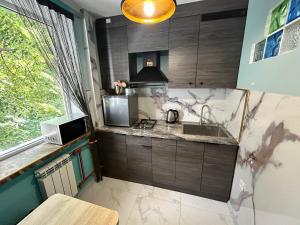 a small kitchen with a sink and a microwave at Lenin Guest House & Tours in Tiraspol