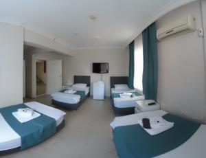 a hospital room with four beds and a tv at Odak Pansiyon in Çanakkale