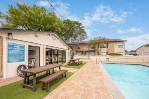 una piscina con tavolo da picnic e panchine accanto a un edificio di Pet-Friendly 1BR Apt - Pool Near All Attractions a New Braunfels