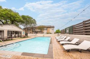 una piscina con sedie a sdraio accanto a un edificio di Pet-Friendly 1BR Apt - Pool Near All Attractions a New Braunfels