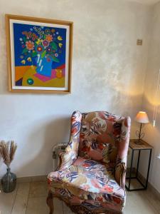 Vaux-sur-SûreLes Sansonnets的客厅配有椅子和墙上的绘画