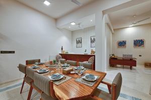 アンジュナにあるMelhor Stays Villa - L-M107 Luxury 4BHK villa with Private pool, Anjunaの木製のテーブルと椅子のあるダイニングルーム