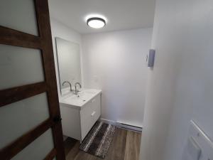 a white bathroom with a sink and a mirror at Aux 4 vents - Auberg'Inn in Carleton-sur-Mer +36 photos