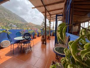 a balcony with a table and chairs and plants at Casa Blue Star in Chefchaouen