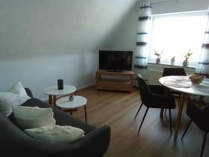 a living room with a couch and two tables and a tv at Ferienwohnung Langenhorst in Raesfeld