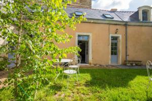una vecchia casa con sedie nel cortile di le gite de l'orangerie a Durtal