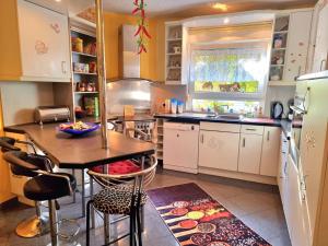 a kitchen with white cabinets and a table and chairs at Haus Kalle in Harlesiel