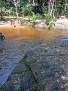 a group of people swimming in a river at Zion camping in Camacari