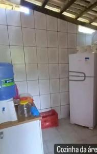 a kitchen with a white tiled wall and a refrigerator at Zion camping in Camacari