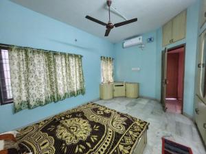 a bedroom with a bed and a ceiling fan at Holiday Home Madurai Bharathi Nagar - FF in Tallākulam