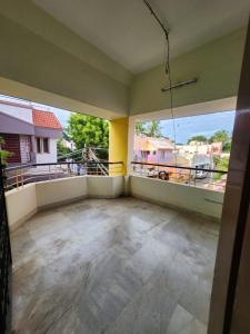 an empty room with large windows and a balcony at Holiday Home Madurai Bharathi Nagar - FF in Tallākulam