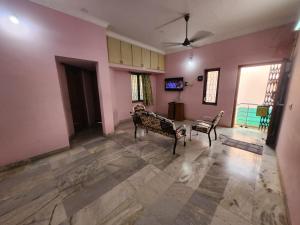a living room with pink walls and wooden floors at Holiday Home Madurai Bharathi Nagar - FF in Tallākulam