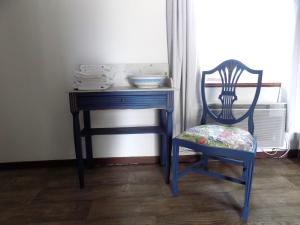 a blue desk with a chair next to a window at La maisonnette in Les Adjots