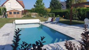 a swimming pool with two chairs in a yard at La Maison d'Enfance in Heimsbrunn