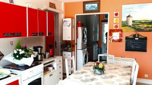 a kitchen with red cabinets and a table with flowers on it at Chez Marie in Cercy-la-Tour
