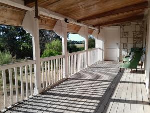 a porch of a house with green chairs at Domaine du Baron in Saint-Martin-lʼAstier +5 photos