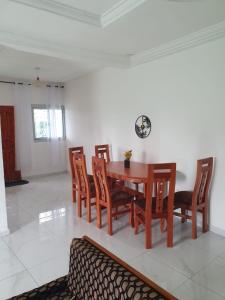 a dining room with a wooden table and chairs at Résidence LIBOUGA - Édéa II in Edéa +11 photos
