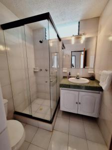 Un baño con ducha, lavabo e inodoro. en Apartamento Melgar, Villa Flórez, en Melgar