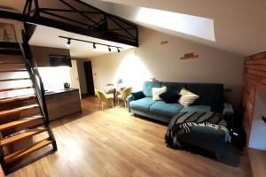 Una sala de estar con un sofá azul y una mesa. en Loft Apartment Old Town - G47, en Cracovia