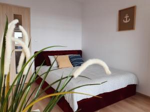 ブワディスワボボにあるApartament Mewka XVIIIのベッドルーム1室(ベッド1台、植物付)