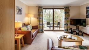 Телевизор и/или развлекательный центр в 2 Bedroom Dog Friendly Cottage At Windermere Marina Village