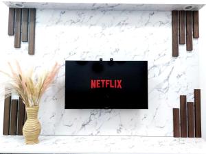 a sign on a wall that reads netflix next to a vase at CupidWood Residensi Ostia Bangi with Pool free NEFLIX, Wifi, Parking in Bandar Baru Bangi +16 photos