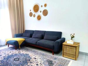 a living room with a blue couch and a table at CupidWood Residensi Ostia Bangi with Pool free NEFLIX, Wifi, Parking in Bandar Baru Bangi