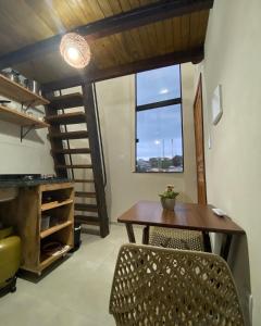Un comedor con mesa y sillas y una ventana. en Cacau Tiny House, en Itacaré