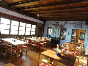 a dining room with tables and chairs and windows at Sintrivanis Mountain in Áno Skotína