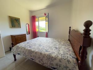a bedroom with a bed and a dresser and a window at Villa trinité in La Trinité