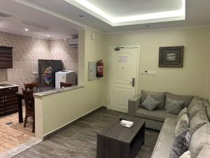 a living room with a couch and a kitchen at شقق برج نوران للشقق المخدومة Nouran Tower Serviced Apartments in Al Khobar