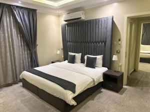 a bedroom with a large bed with a black headboard at شقق ربيع الخزمى للشقق المخدومة rabie alkhozama for serviced apartmentp in Al Khobar
