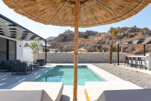 a swimming pool with an umbrella and tables and chairs at Zen Club Luxury Villas in Kolimbia