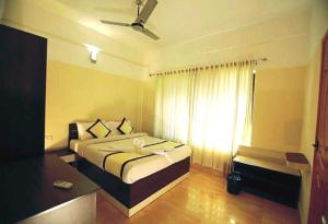 Ein Bett oder Betten in einem Zimmer der Unterkunft Hotel Tayas, Thiruvananthapuram
