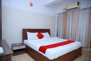ein Schlafzimmer mit einem großen Bett mit roten Kissen in der Unterkunft Hotel Tayas, Thiruvananthapuram in Trippapur + 24 Fotos