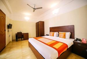 ein Schlafzimmer mit großem Bett und Schreibtisch in der Unterkunft Hotel Tayas, Thiruvananthapuram in Trippapur