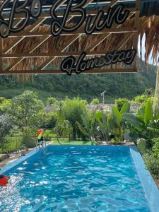 a large blue swimming pool with a sign above it at Bó Bun Homestay Mộc Châu in Mộc Châu
