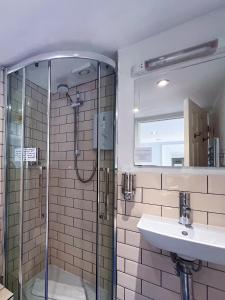 a bathroom with a glass shower and a sink at INNit Joy in Brighton & Hove