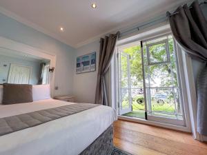 a bedroom with a bed and a large window at INNit Joy in Brighton & Hove