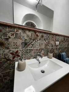 Un baño con un lavabo blanco y un espejo. en Appartamento villa del borgo, en Deiva Marina